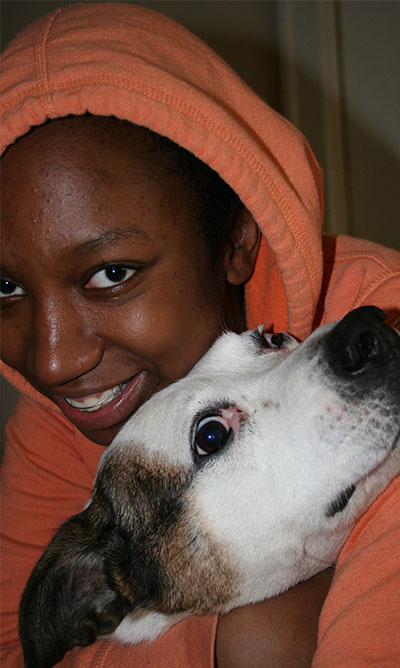 girl with arms around pit bull