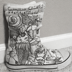 White high top shoes with a wide array of different items drawn on it with a thin black sharpie pen