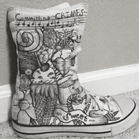 white high top shoe with black sharpie ink drawings on it