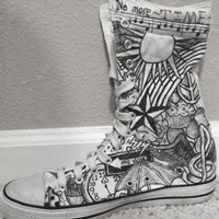 white high top shoe with black sharpie ink drawings on it