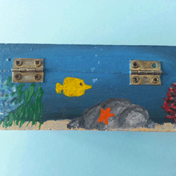 Wooden box with a blue background and fish painted on it